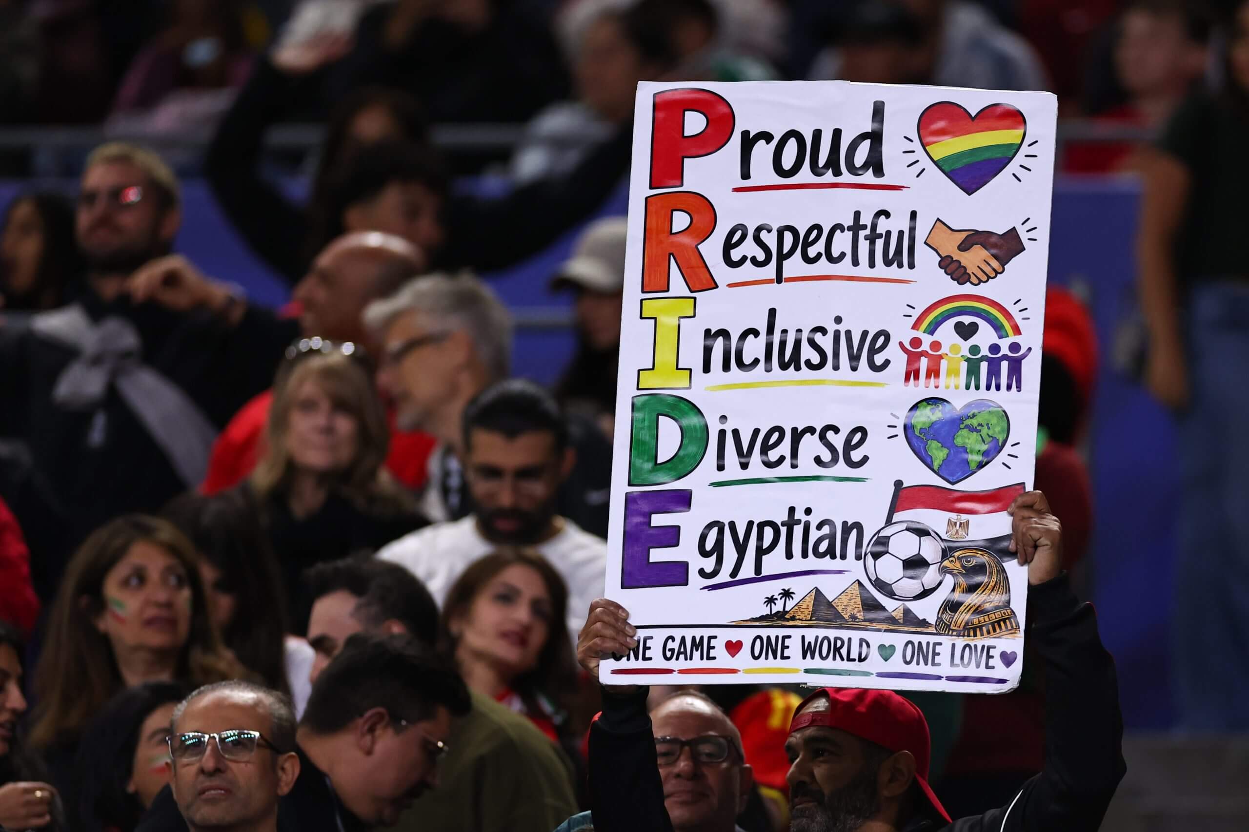 A fan holds up a custom-made Pride sign during the Egypt-Iran match (Robbie Jay Barratt / AMA via Getty Images)