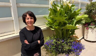 Artist Farideh Golbahar with the flowers she tends at her Jerusalem home, May 2026 (Jessica Steinberg/Times of Israel)