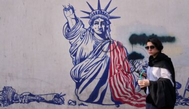 A woman walks past an anti-American mural on the wall of the former U.S. Embassy, now a museum, in Tehran, Iran, Friday, June 12, 2026. (AP Photo/Vahid Salemi)