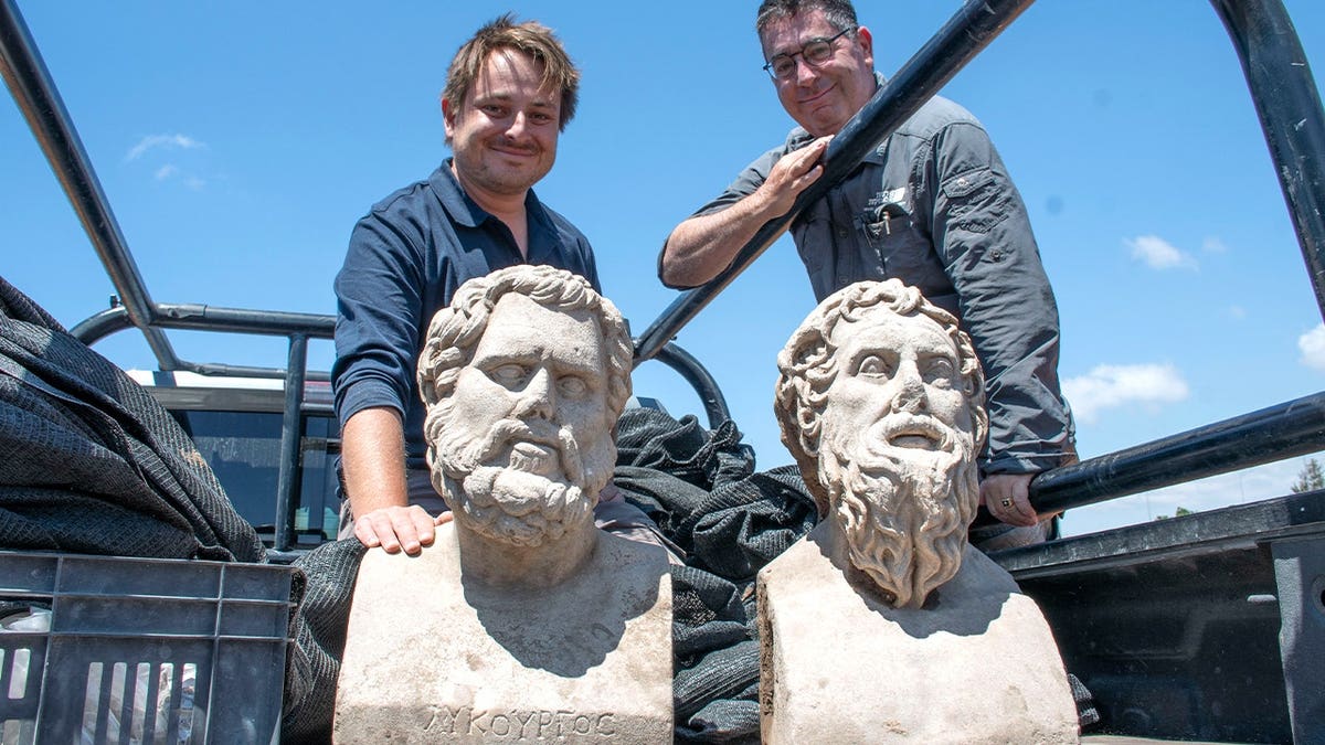 Archaeologists standing next to ancient statues found in Israel