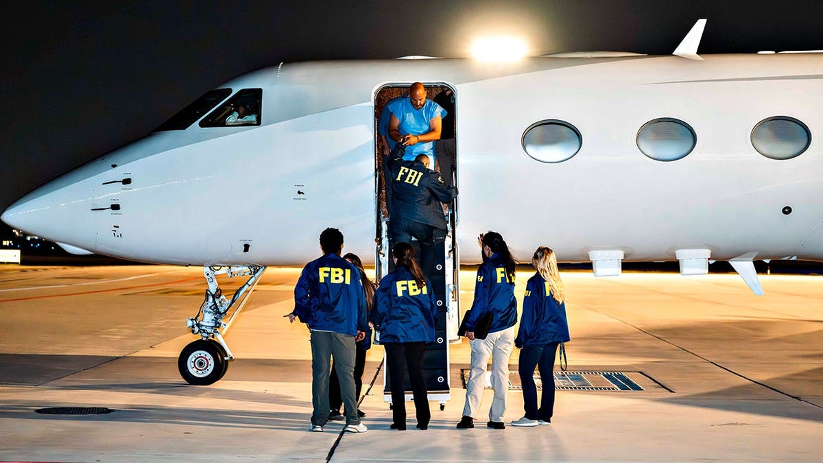 Ibrahim Khaldoon Hilmi exits plane as FBI officials stand on tarmac