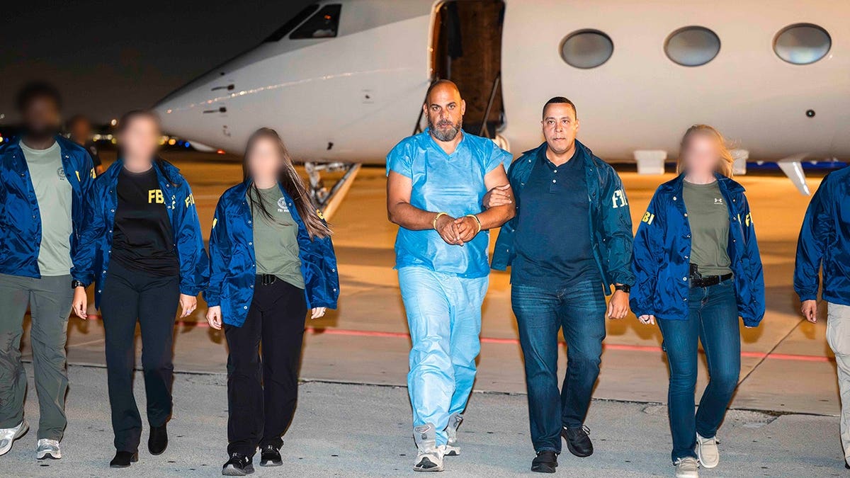 FBI agents escorting Ibrahim Khaldoon Hilmi from a plane