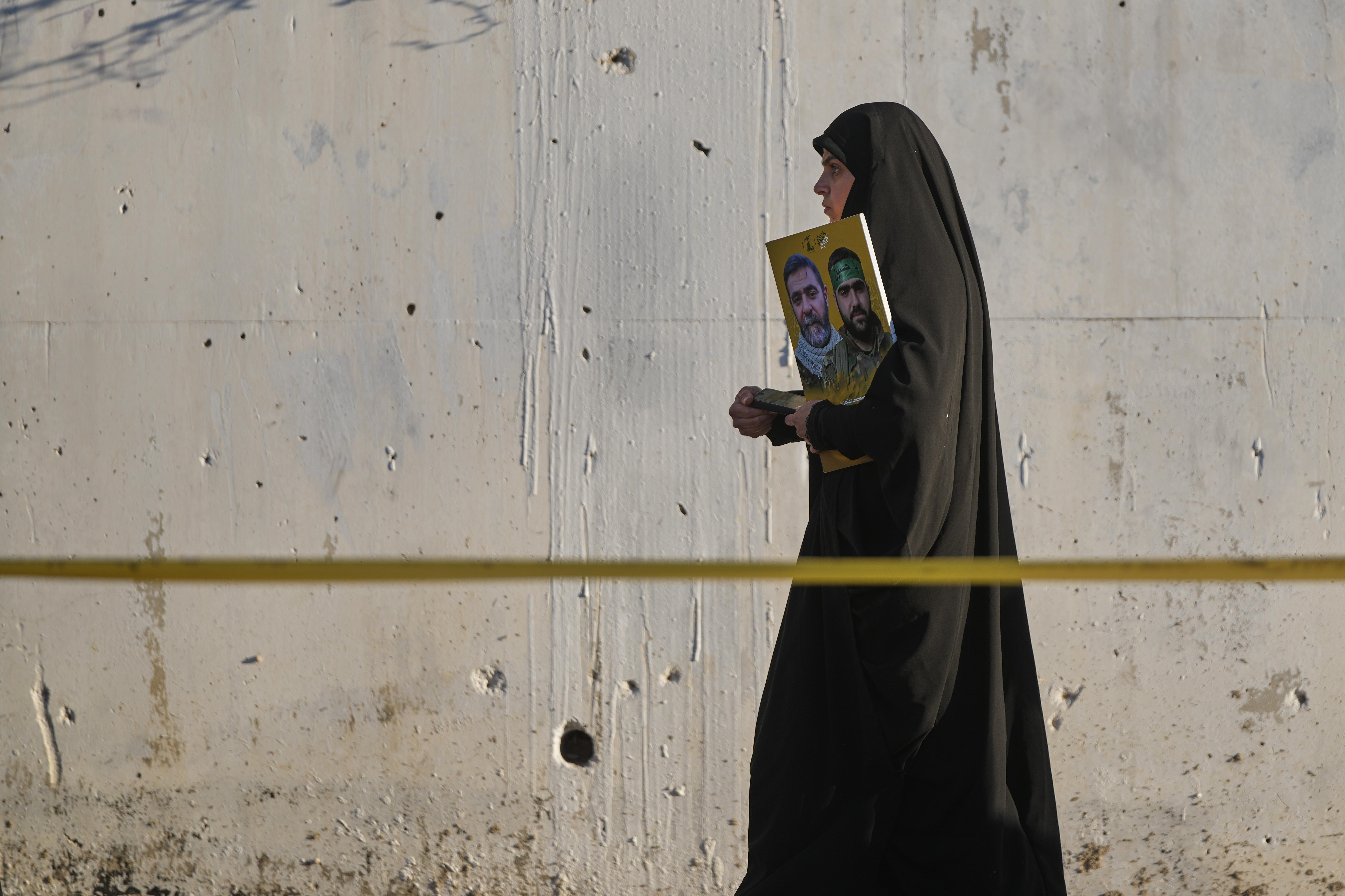 A woman holds a poster of Hezbollah fighters during a...