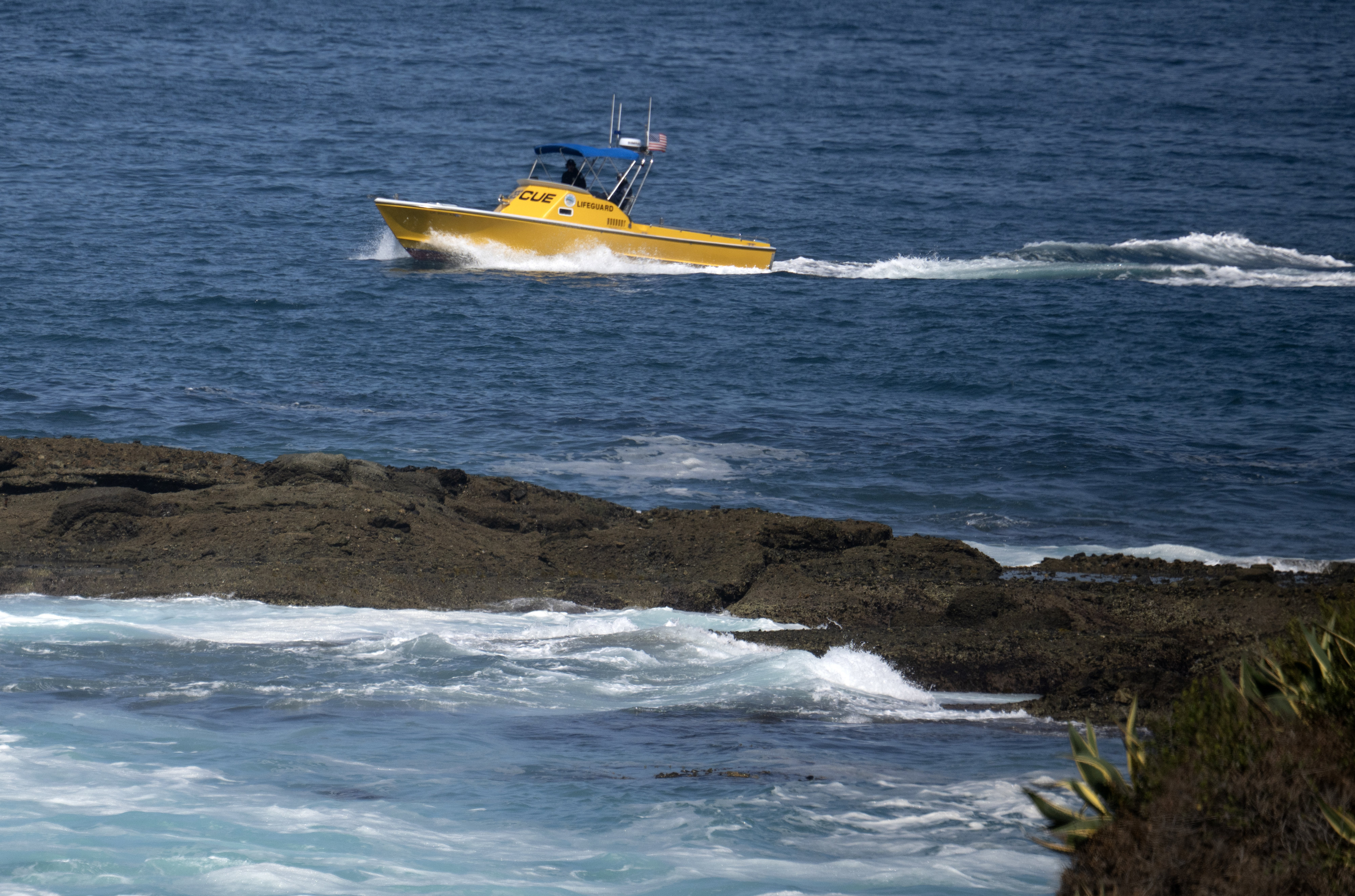 A lifeguard rescue boat cruises around the area where a...