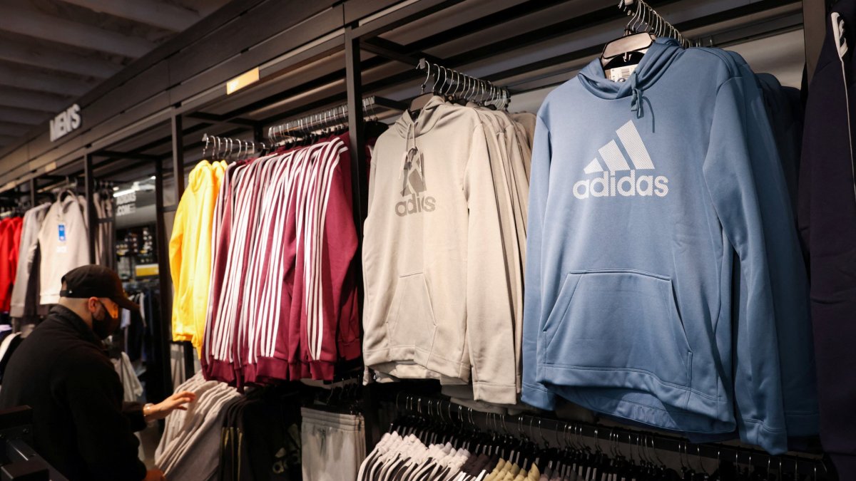 A person looks at clothes in the Adidas store at the Woodbury Common Premium Outlets in Central Valley, New York, U.S., February 15, 2022. REUTERS/Andrew Kelly