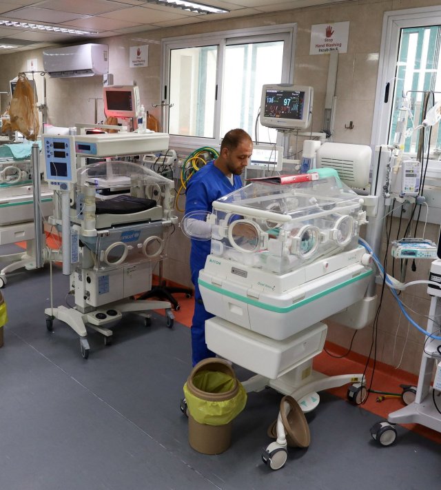 A medical worker assists a premature Palestinian baby who lies in an incubator at the maternity ward of Shifa Hospital, which according to health officials is about to shut down as it runs out of fuel and power, as the conflict between Israel and the Palestinian Islamist group Hamas continues, in Gaza City October 22, 2023. REUTERS/Mohammed Al-Masri