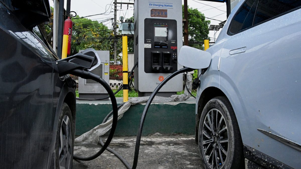 This photograph taken on April 29, 2026 shows people charging their electric vehicles at a charging station in Kathmandu. As global fuel markets reel from the Middle East war, motorists in Nepal are increasingly turning to electric vehicles, with high demand putting a strain on dealerships. (Photo by Prakash MATHEMA / AFP via Getty Images) / TO GO WITH 'Nepal-Transport-Automobile-Energy' FOCUS