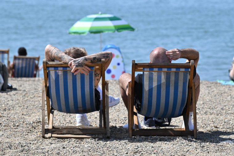 SOUTHEND, ENGLAND - MAY 25: Two men relax in deck chairs on Jubilee beach during the hot weather on May 25, 2026 in Southend, England. An exceptional bank holiday heatwave is currently bringing record-breaking weather to England with temperatures forecast to climb into the low 30s by Monday. The intense high pressure has prompted the UK Health Security Agency (UKHSA) to issue rare, amber heat alerts across multiple regions due to the health risks for vulnerable people and extreme UV levels. (Photo by John Keeble/Getty Images)