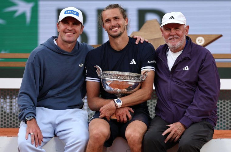 Tennis - French Open - Roland Garros, Paris, France - June 7, 2026 Germany's Alexander Zverev poses for a photograph with the trophy alongside, his brother, Mischa Zverev and dad, Alexander Zverev Sr. as he celebrates winning the final against Italy's Flavio Cobolli REUTERS/Stephane Mahe