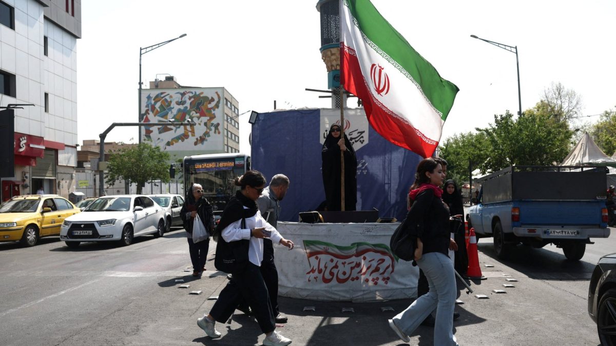 A woman holds an Iranian flag on a street in Tehran, Iran, June 10, 2026. Majid Asgaripour/WANA (West Asia News Agency) via REUTERS ATTENTION EDITORS - THIS PICTURE WAS PROVIDED BY A THIRD PARTY. ATTENTION EDITORS - THIS PICTURE WAS PROVIDED BY A THIRD PARTY. ISRAEL OUT. NO COMMERCIAL OR EDITORIAL SALES IN ISRAEL. NO ACCESS FOR ISRAELI MEDIA. NO USE BBC PERSIAN. NO USE VOA PERSIAN. NO USE MANOTO. NO USE IRAN INTERNATIONAL. NO USE RADIO FARDA. DIGITAL: NO USE BBC PERSIAN. NO USE VOA PERSIAN. NO USE MANOTO. NO USE IRAN INTERNATIONAL. NO USE RADIO FARDA.