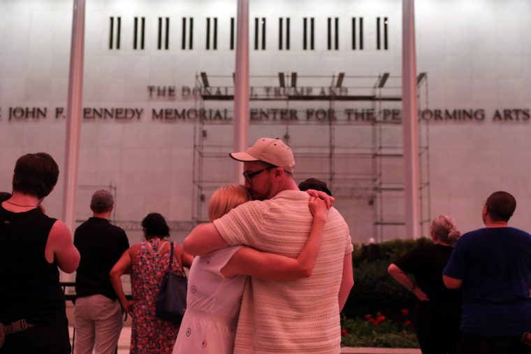 A couple kiss in front of the John F. Kennedy Center for the Performing Arts, Friday, June 12, 2026, in Washington. (AP Photo/Rahmat Gul)
