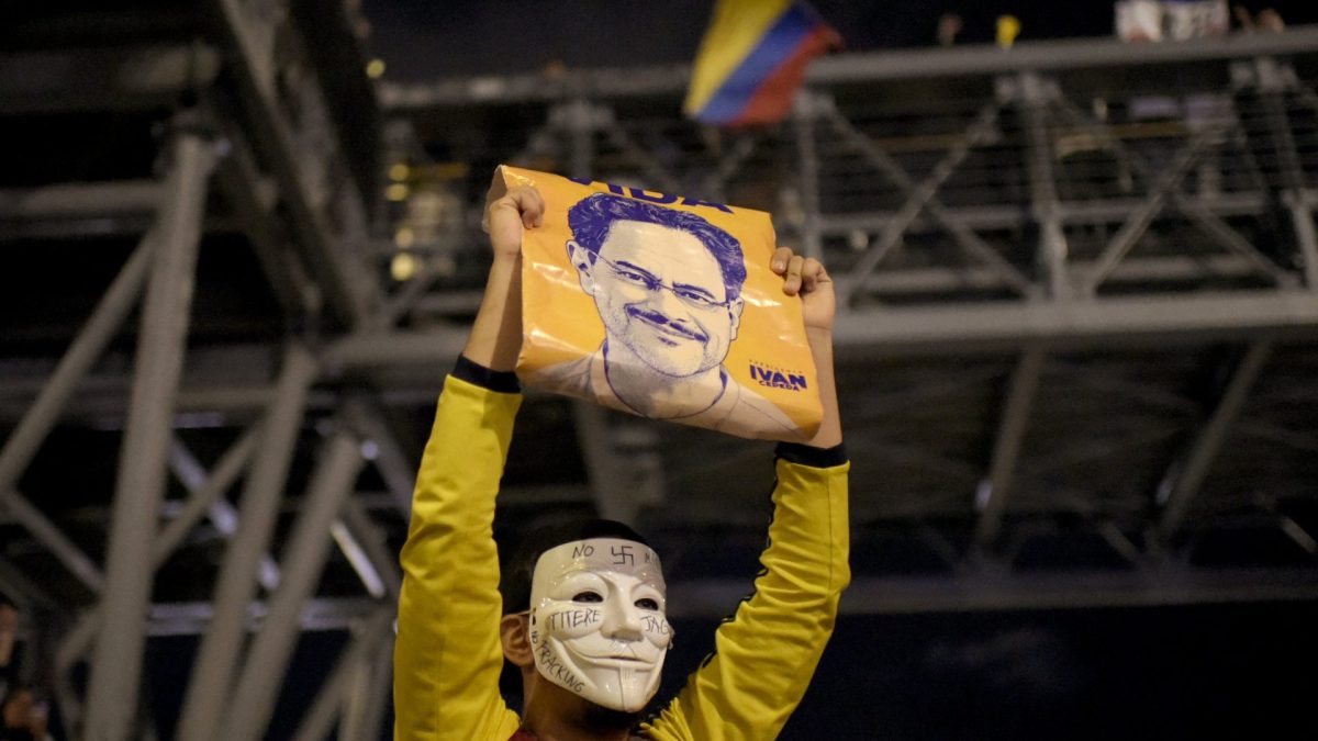 A supporter of Colombia's presidential candidate Ivan Cepeda of the ruling Pacto Historico party wears a Guy Fawkes mask following results of the presidential runoff election in Bogota on June 21, 2026. A flamboyant US-backed lawyer who has never held public office narrowly won Colombia's presidential runoff on June 21, swinging the country hard to the right on a promise to wage war against drug-running guerrilla groups. With more than 99 percent of polling centers reporting, Abelardo de la Espriella had 49.67 percent of the vote, an unassailable lead over his rival, left-wing Senator Ivan Cepeda who trailed at 48.69 percent, according to official results. (Photo by Sebastian BARROS / AFP via Getty Images)