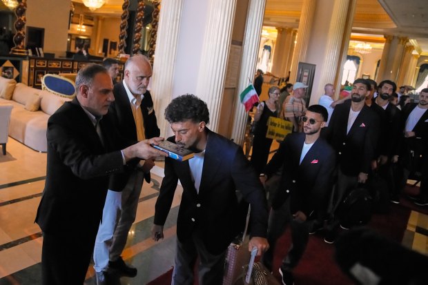 Iran's players kiss the Muslim's holiest book Quran as they leave to Antalya airport, southern Turkey, Saturday, June 6, 2026, before departing to Tijuana, Mexico, for the World Cup soccer tournament. (AP Photo/Khalil Hamra)