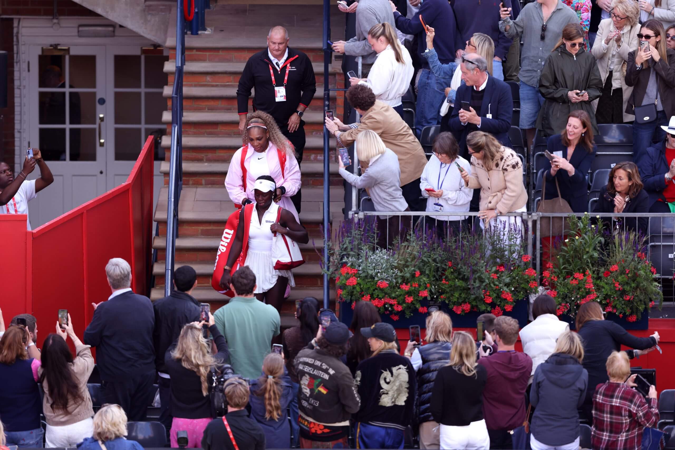 Serena Williams and Victoria Mboko walk down the stairs at Queen's.