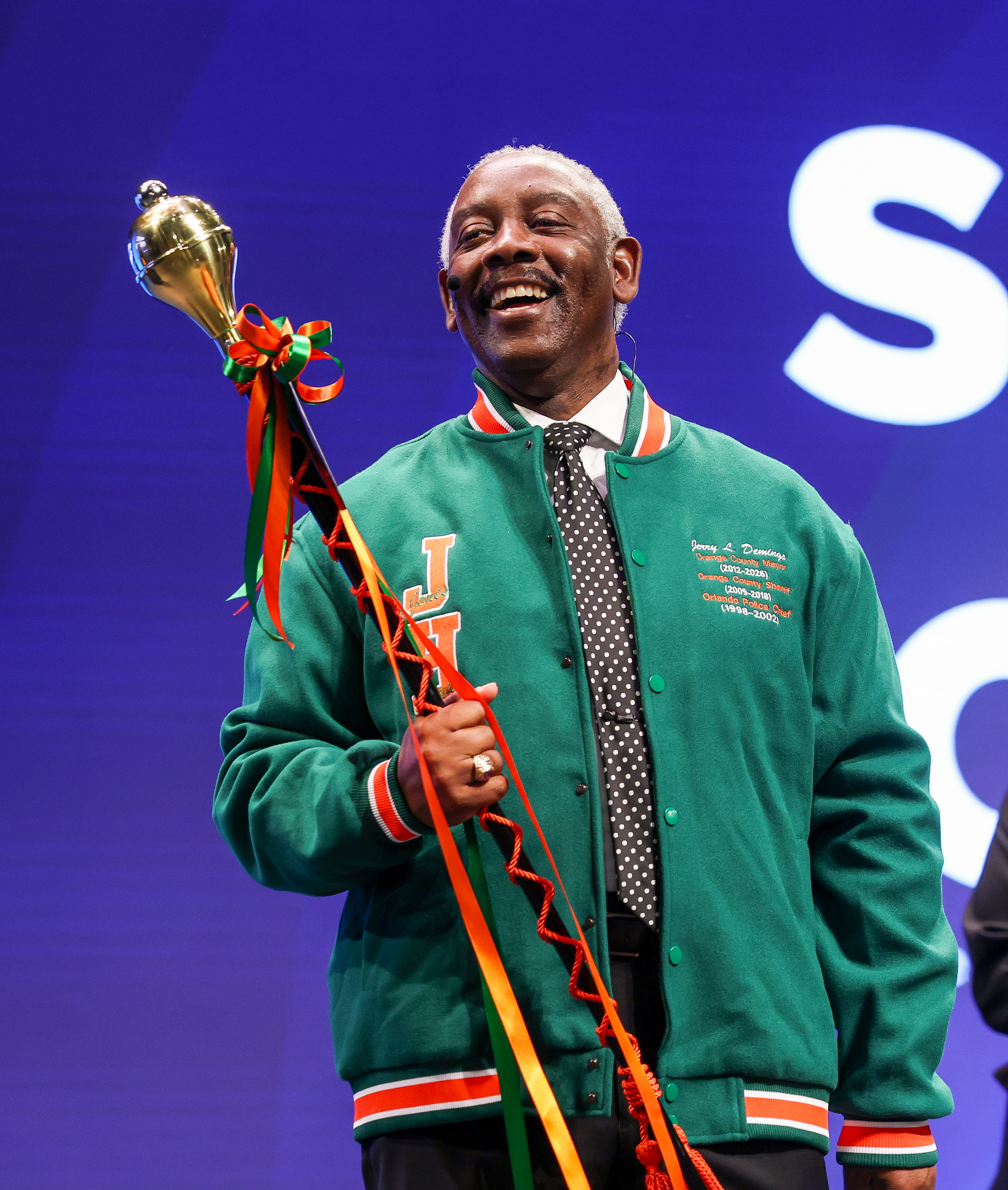 Orange County Mayor Jerry Demings holds the drum major baton...