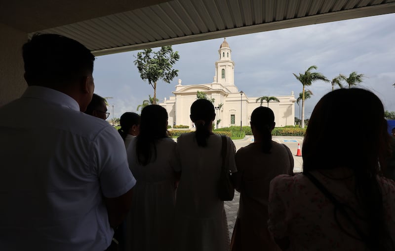 Attendees wait under cover from the rain before entering the Bacolod Philippines Temple for the dedication in Bacolod City, Philippines, on Sunday, May 31, 2026.