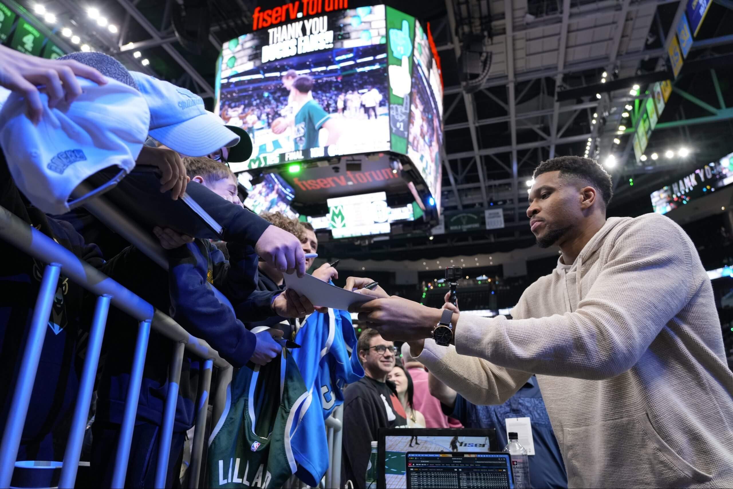 Giannis Antetokounmpo signs autographs for Bucks fans at the end of the 2025-26 regular season.