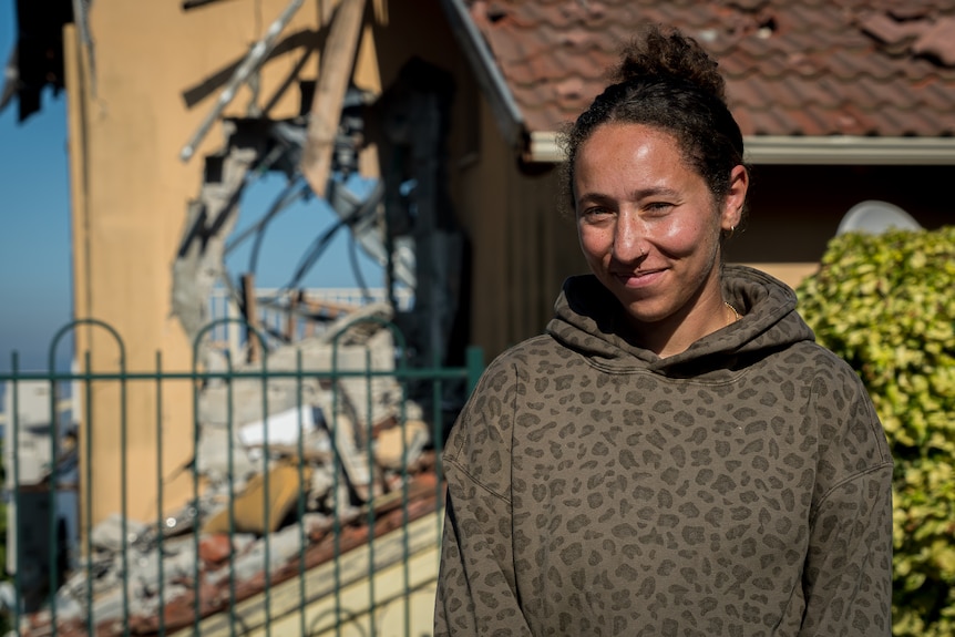 A close up of a woman wearing a jumper and smiling.
