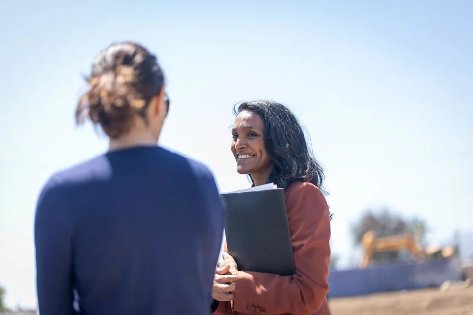 Los Angeles mayoral candidate Nithya Raman, right, talks to a person in the Palisades.