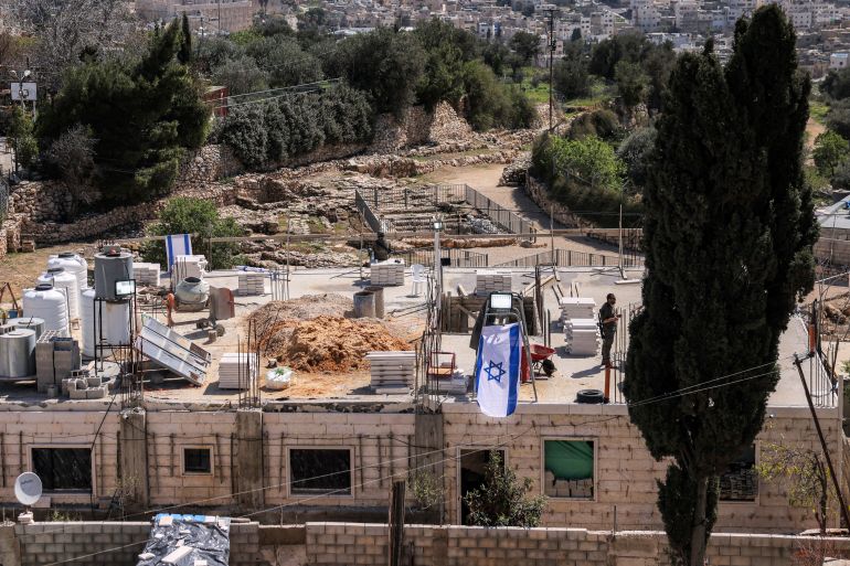 An Israeli flag is set atop the Palestinian Ayoub Abdel-Basit al-Tamimi family home, which was allegedly taken over by Israeli settlers overnight, in Hebron city near the Israeli settlement area of Tel Rumeida in the occupied West Bank on March 24, 2025.