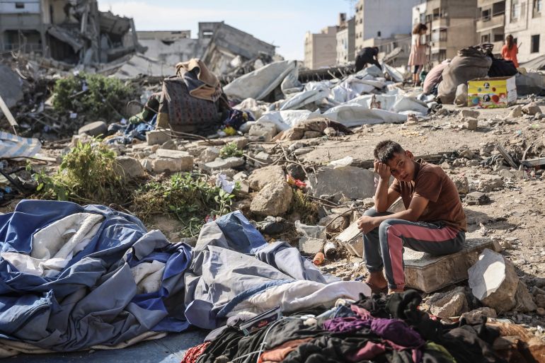 A Palestinian boy sits at the site of an overnight Israeli military strike on structures and tents housing displaced families in Gaza City