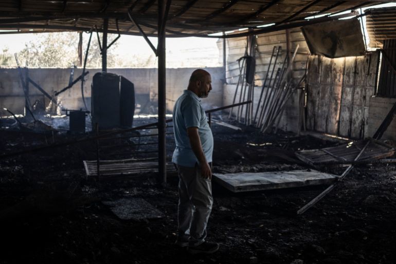 Palestinian Nazem Saleh Shoman stands inside a pen at a sheep farm that was set on fire the previous night by Israeli settlers in the Palestinian village of Abu Falah in the central occupied West Bank on June 2, 2026.