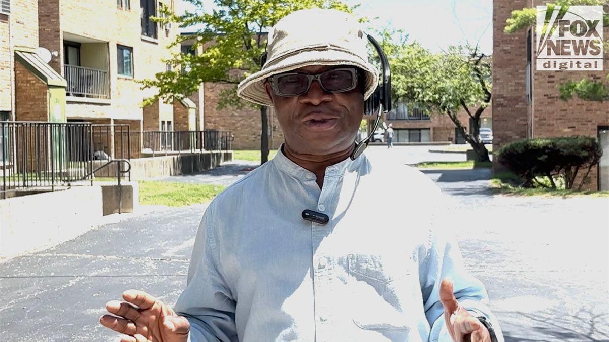 Akoma Amanze wearing a white hat and light shirt.