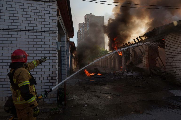 Rescue workers put out a fire of a car workshop damaged after a Russian strike on Kyiv, Ukraine, on Tuesday, June 2, 2026. (AP Photo/Evgeniy Maloletka)