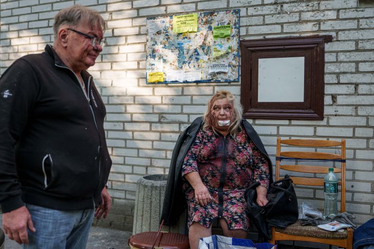 Olena Dniprovska, 65, and her husband Yevhen Dniprovskiy, 64, both injured in a Russian strike, sit in the yard of their damaged house in Kyiv, Ukraine, on Tuesday, June 2, 2026. (AP Photo/Evgeniy Maloletka)