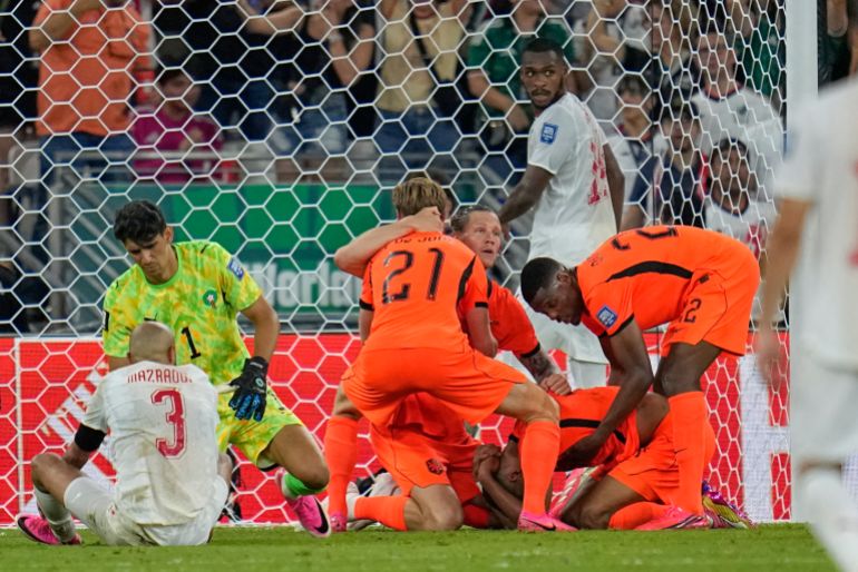 Netherlands' Cody Gakpo, kneeling, is congratulated by teammates after scoring his team's first goal during the World Cup round of 32 soccer match between the Netherlands and Morocco in Guadalupe, near Monterrey, Mexico, Monday, June 29, 2026. (AP Photo/Ricardo Mazalan)