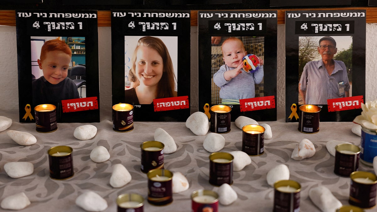 Photos of the Bibas family and Oded Lifshitz displayed next to candles in a dining room