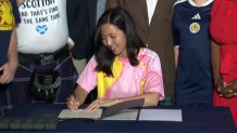 Flanked by members of the Tartan Army, Boston Mayor Michelle Wu signs letters of intent on Thursday, June 18, 2026, for Boston and Glasgow to become sister cities.