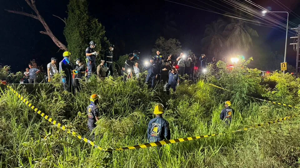 Rescue workers, police officers and forensic technicians search a grassy area near a railway track before police found a suitcase containing the body of a 17-year-old Thai girl in Pattaya City, on June 27. - Teerasak Suttativong/Reuters