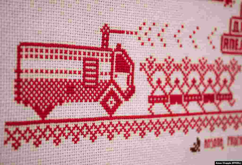 A truck-mounted water cannon and protesters depicted in a cross-stitch panel.<br><br>Bazlova adds that the pictogram-like representations make it "immediately understandable what's going on" for both foreign and Belarusian audiences.<br><br>