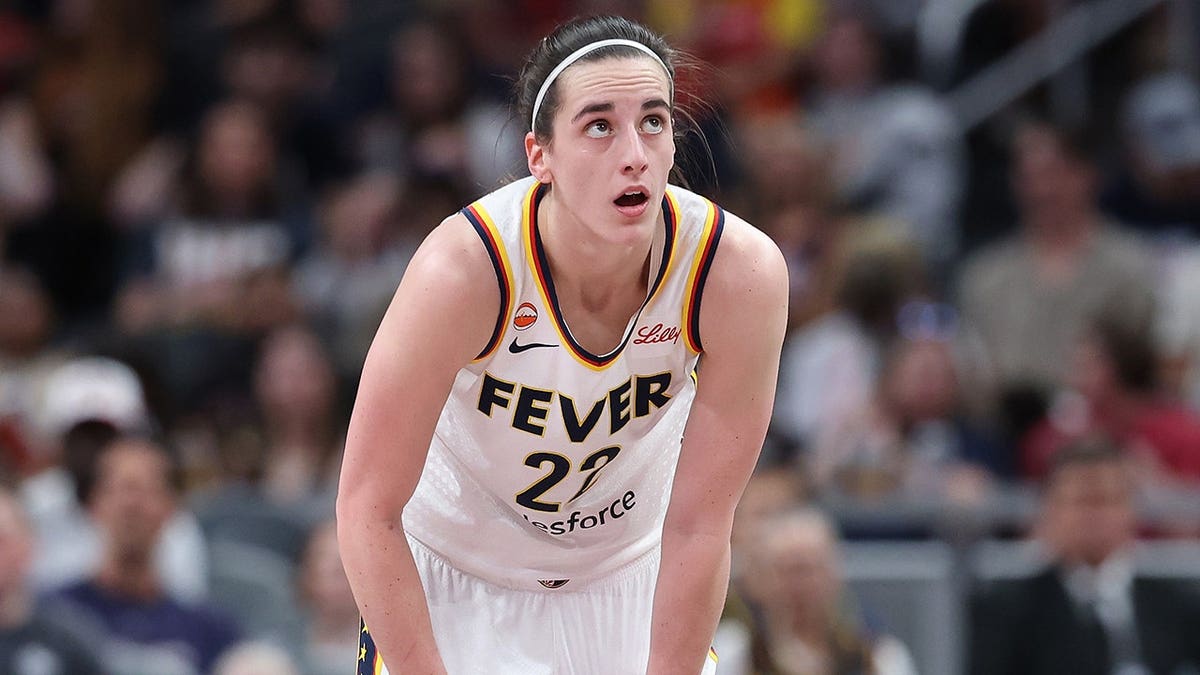 Caitlin Clark wearing Indiana Fever uniform playing basketball at Gainbridge Fieldhouse