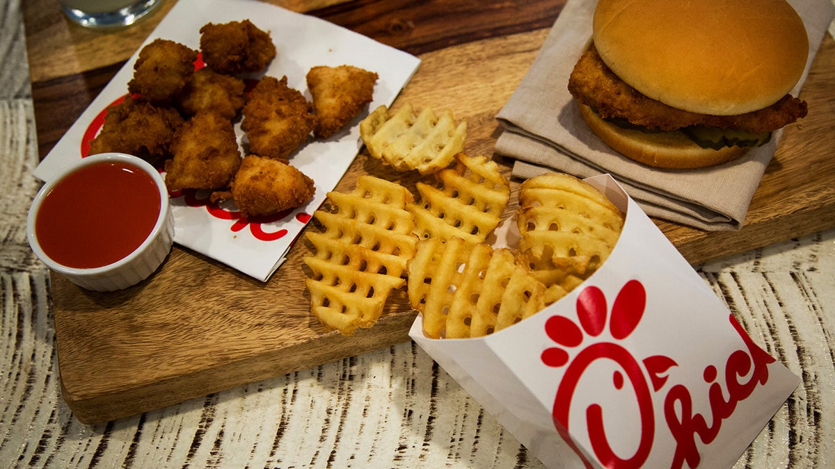 Chicken nuggets french fries and fried chicken sandwich arranged on a plate