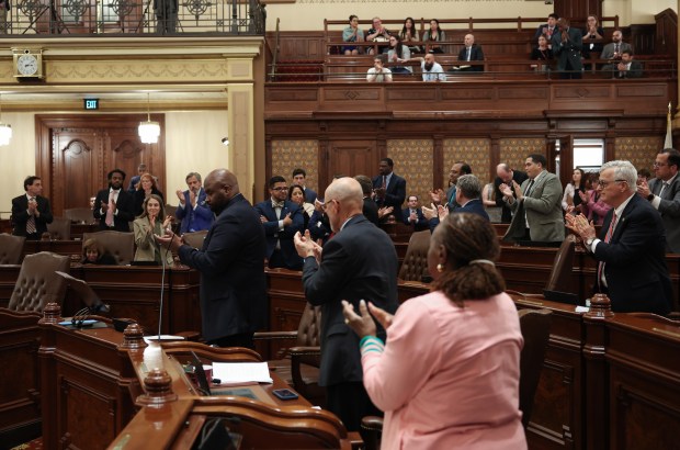 State Sen. Elgie Sims Jr., center left, leads fellow senators in applause on the efforts of colleagues who worked on the budget before its passing on the final night of the spring legislative session at the State Capitol early on June 1, 2026, in Springfield. (John J. Kim/Chicago Tribune)