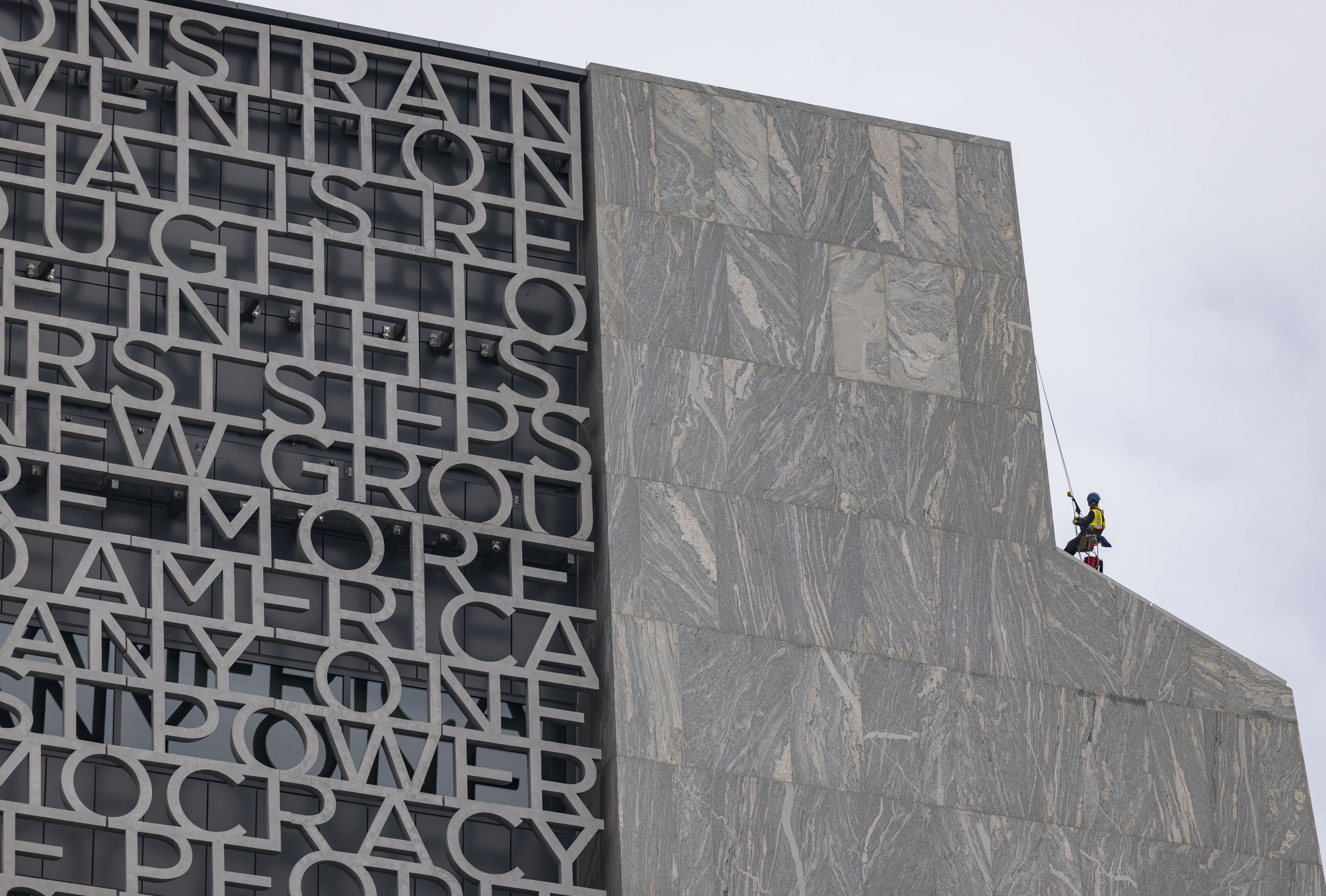 A worker climbs outside the building as preparations continue at...