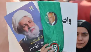 A woman holds pictures of Hezbollah leader Naim Qassem (left) and Lebanese Parliament Speaker Nabih Berri at Martyrs’ Square in central Beirut on April 30, 2026.
