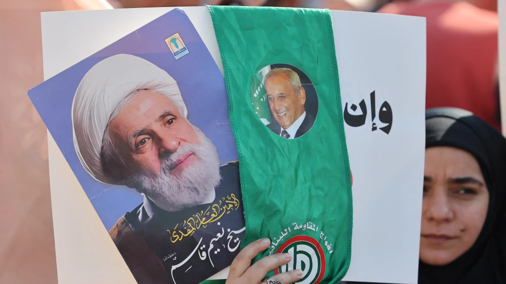 A woman holds pictures of Hezbollah leader Naim Qassem (left) and Lebanese Parliament Speaker Nabih Berri at Martyrs’ Square in central Beirut on April 30, 2026.