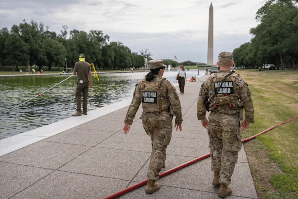 National Guard members walk past a National Park Service employee using a vacuum to clean the Lincoln Memorial Reflecting Pool, Friday, June 19, 2026, in Washington.