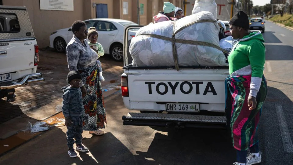 A pickup truck arrives outside the Zimbabwean Consulate General in Johannesburg on June 28, carrying a family with their belongings seeking assistance for return to Zimbabwe. - Emmanuel Croset/AFP/Getty Images