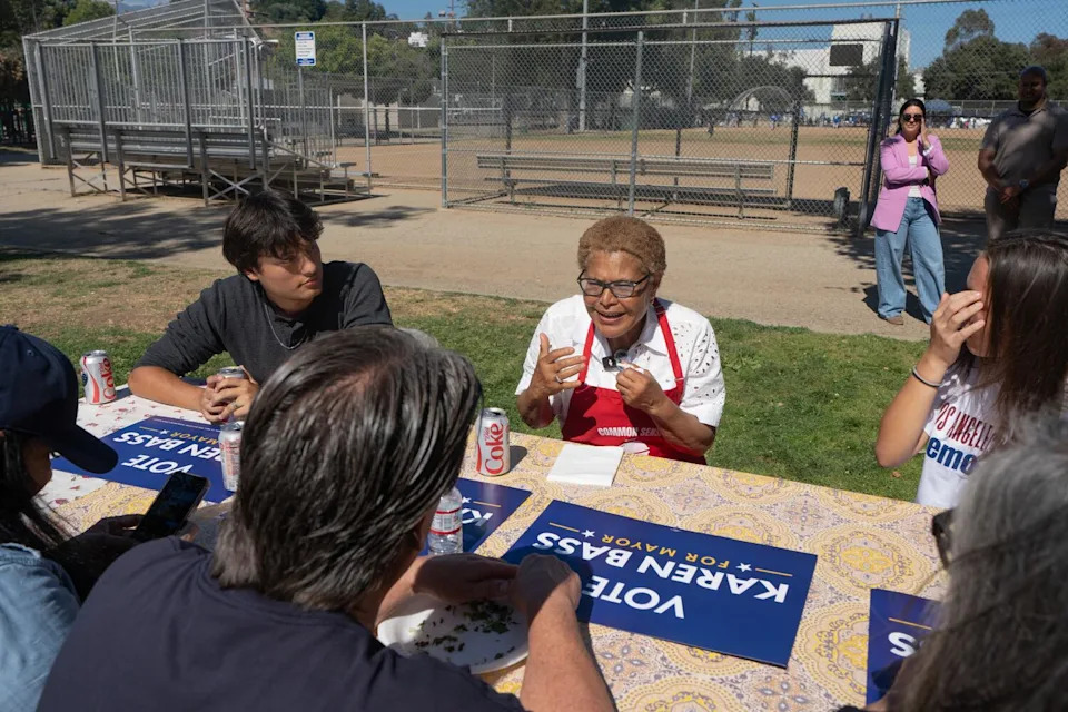Los Angeles Mayor Karen Bass speaks to people in front of signs.