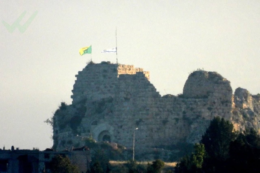 Two flags raised over a medieval castle.
