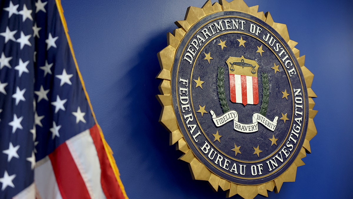 FBI logo displayed on a building exterior next to an American flag in Los Angeles
