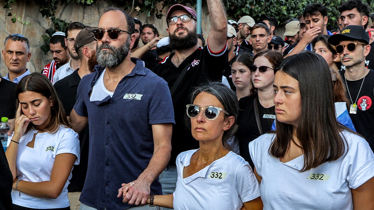 Jonathan Polin and Rachel Goldberg-Polin standing together at a funeral in Jerusalem