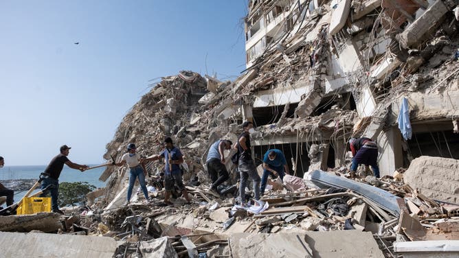 LA GUAIRA, VENEZUELA - JUNE 26: Family members and volunteers search through the rubble after two 17-story buildings at the Belo Horizonte residential complex collapsed in Catia La Mar, La Guaira, Venezuela, on June 26, 2026.