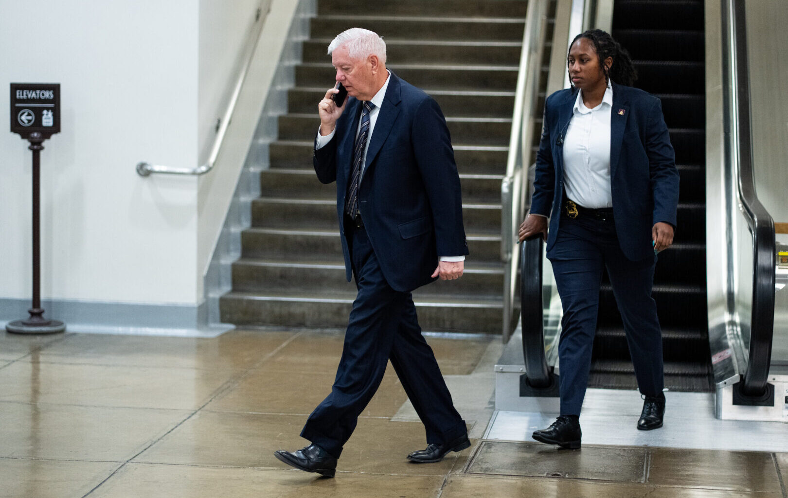 Sen. Lindsey Graham, R-S.C., walks through the Senate subway area in the Capitol with a security detail on June 2.