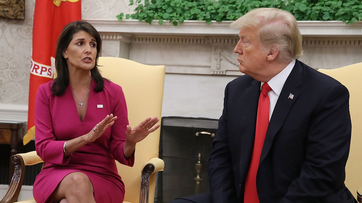 President Donald Trump standing with UN Ambassador Nikki Haley in the Oval Office