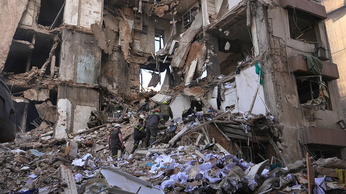 Lebanese civil defense workers searching rubble of destroyed building in Beirut